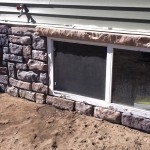 basement window looking onto patio before paving stone are placed